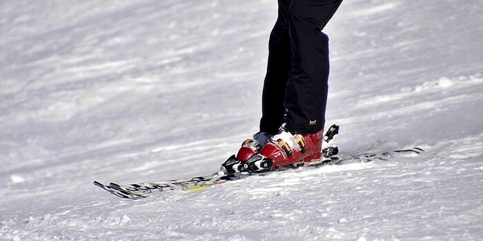 closeup on legs of skier on skis sliding down slopes