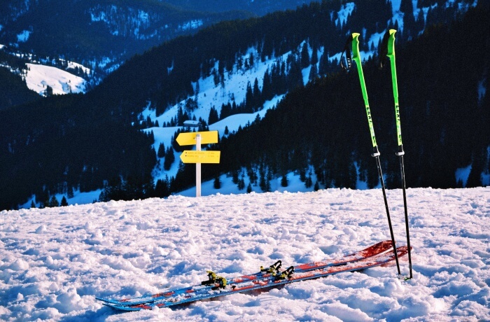 ski and ski poles stuck in snow on slope