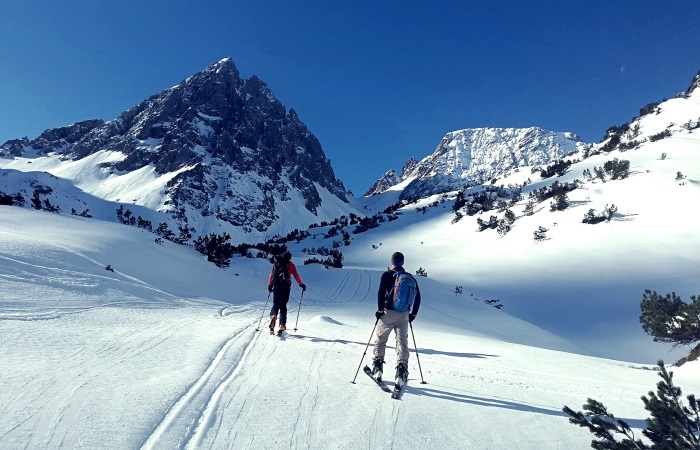 backcountry skiiers on trail in the mountains 
