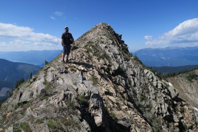 man on top of rocky hill 