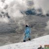 snowboarder on snowboard with best snowboard boots on cloudy snowy mountain