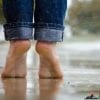 women feet in jeans in the rain