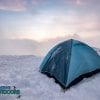 Camping blue tent at snowy hill in foggy