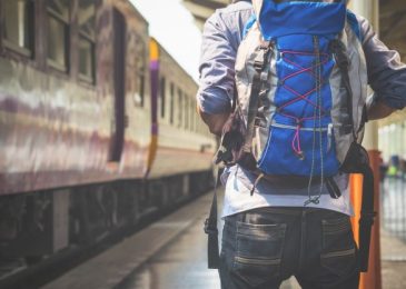 Man carrying ultralight backpack awaiting on railway platform